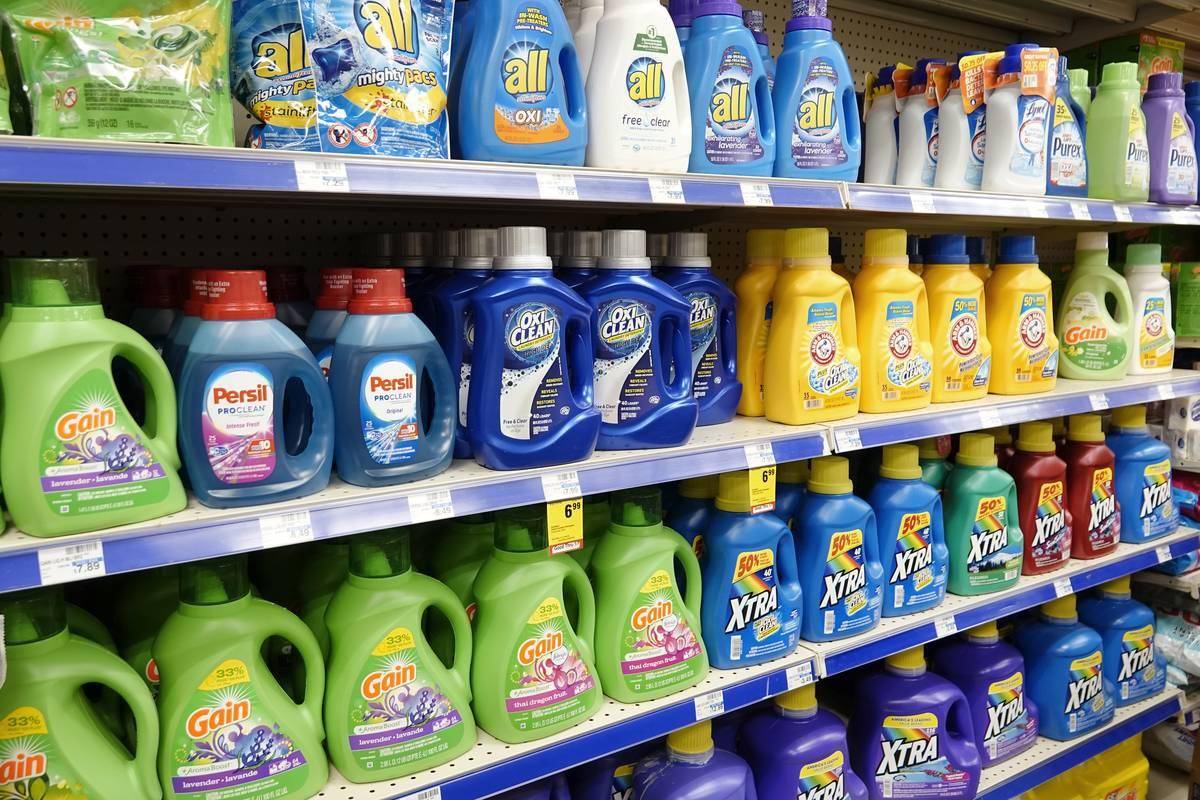 Several brands of laundry detergent sit on shelves in a CVS Pharmacy.