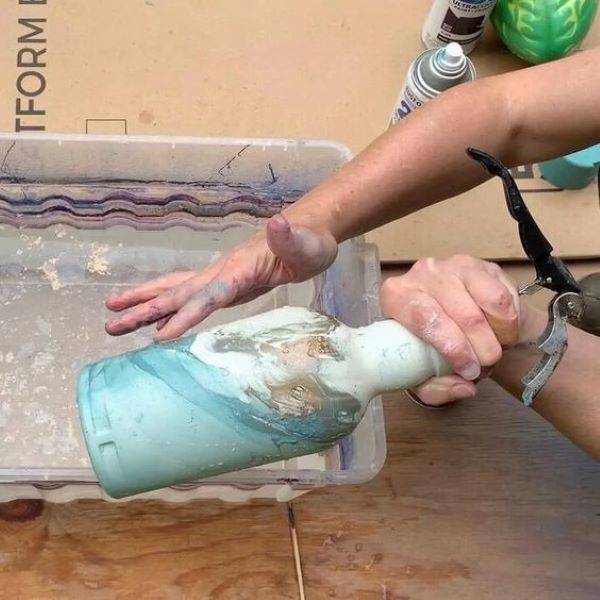 Person painting a vase.