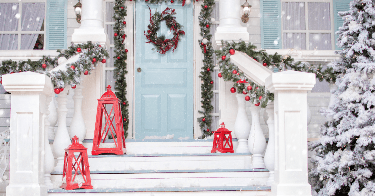 Snow covered front of a house with Christmas decoration.