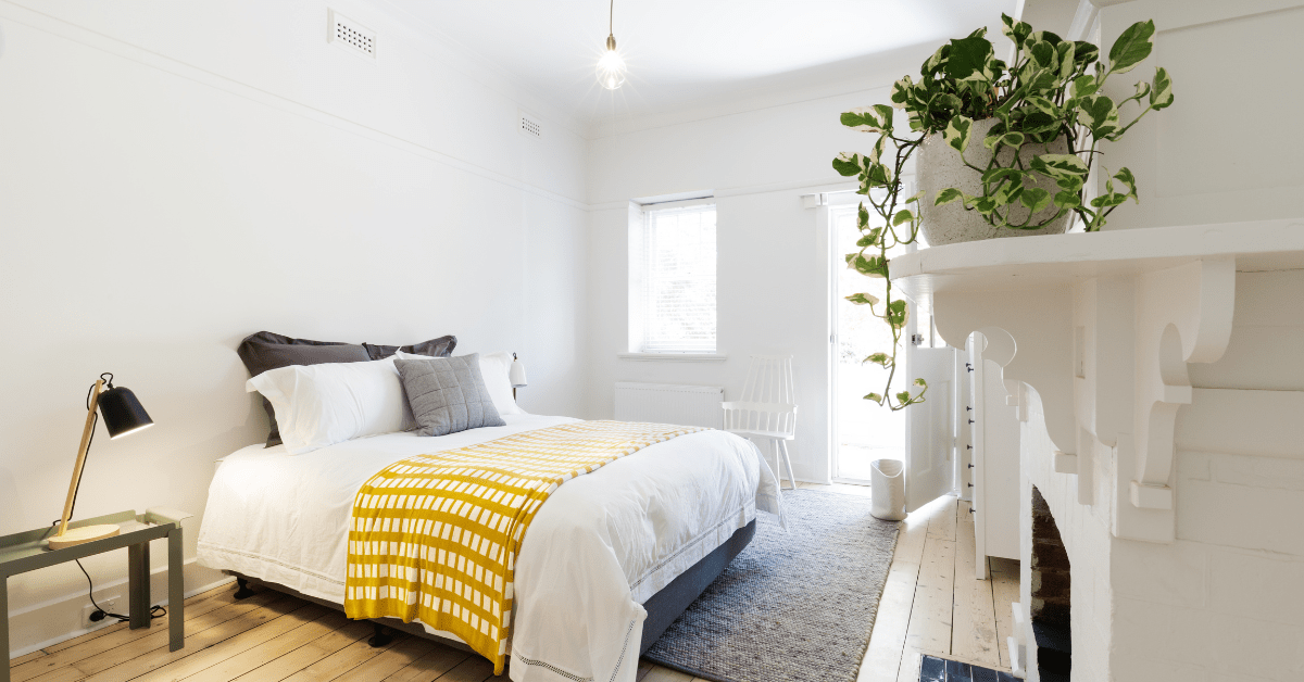 Modern bed with yellow throw blanket.