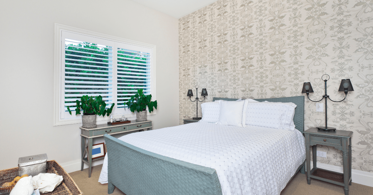 Traditional guest room with plants and white bedding.