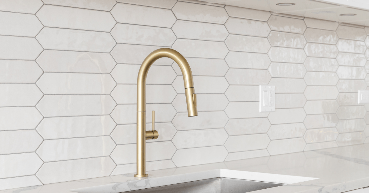 Gold fixtures flanked with white tile and grey grout.