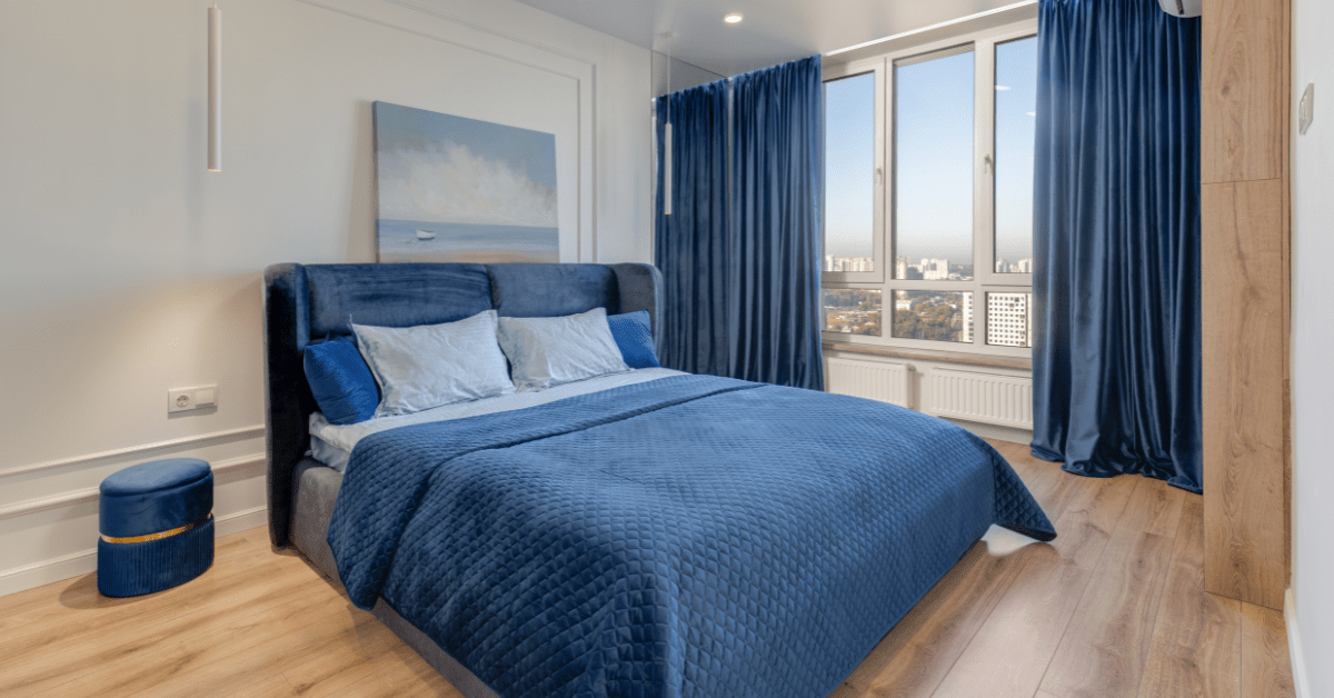 Blue bed in a large bedroom.