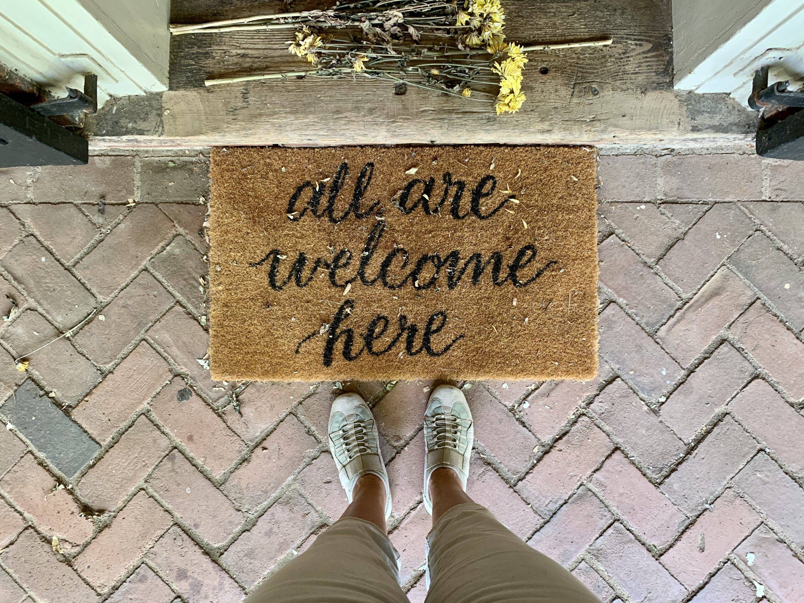 all are welcome here straw doormat at front door