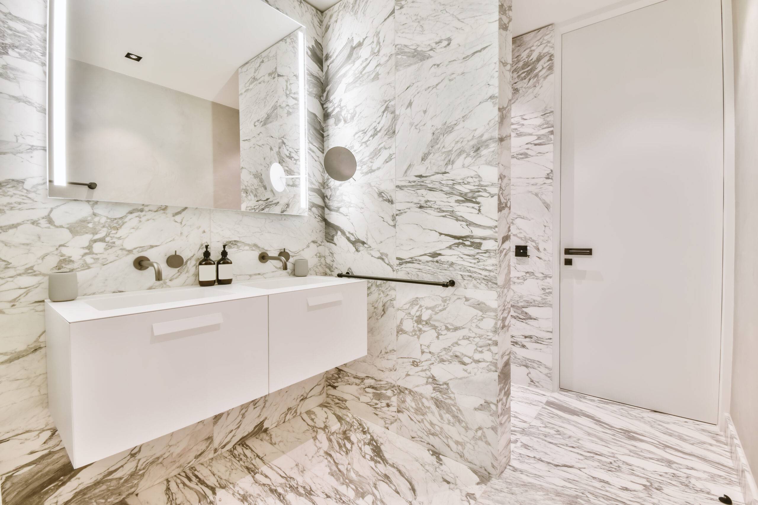 A bathroom with marble walls and flooring.