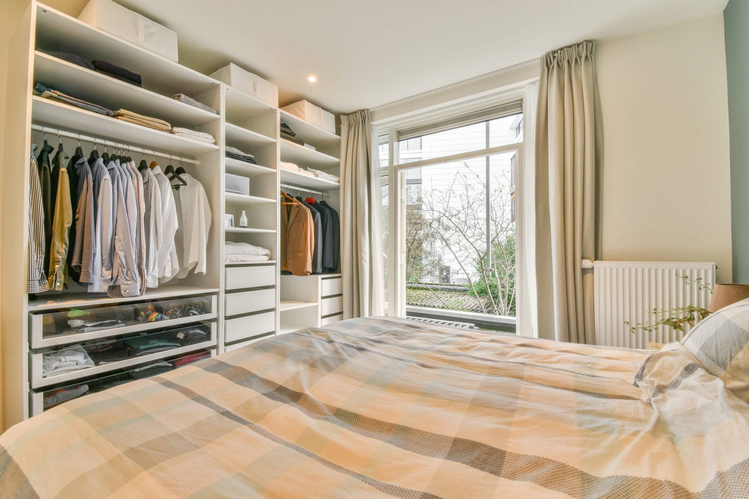 A built-in wall closet unit across from a bed.