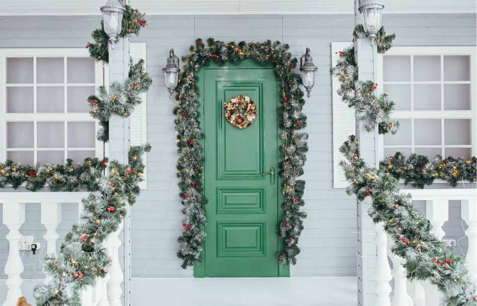 A front door decorated with festive Christmas garland.