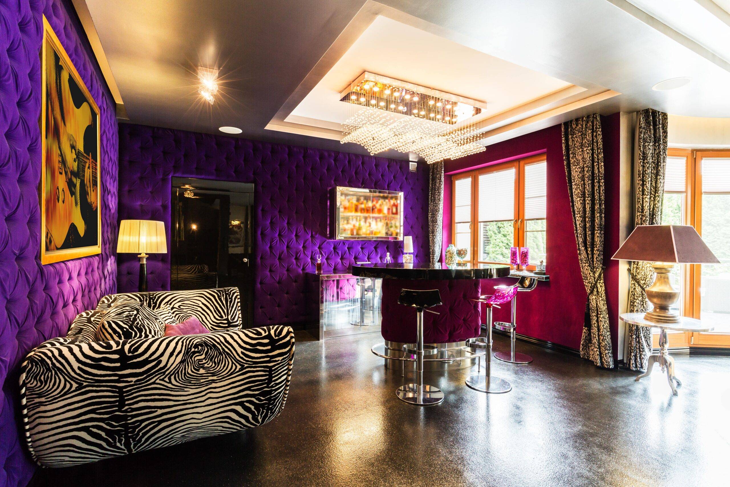 A loud, 2000's era style room with purple velvet cushioned walls and a zebra print couch