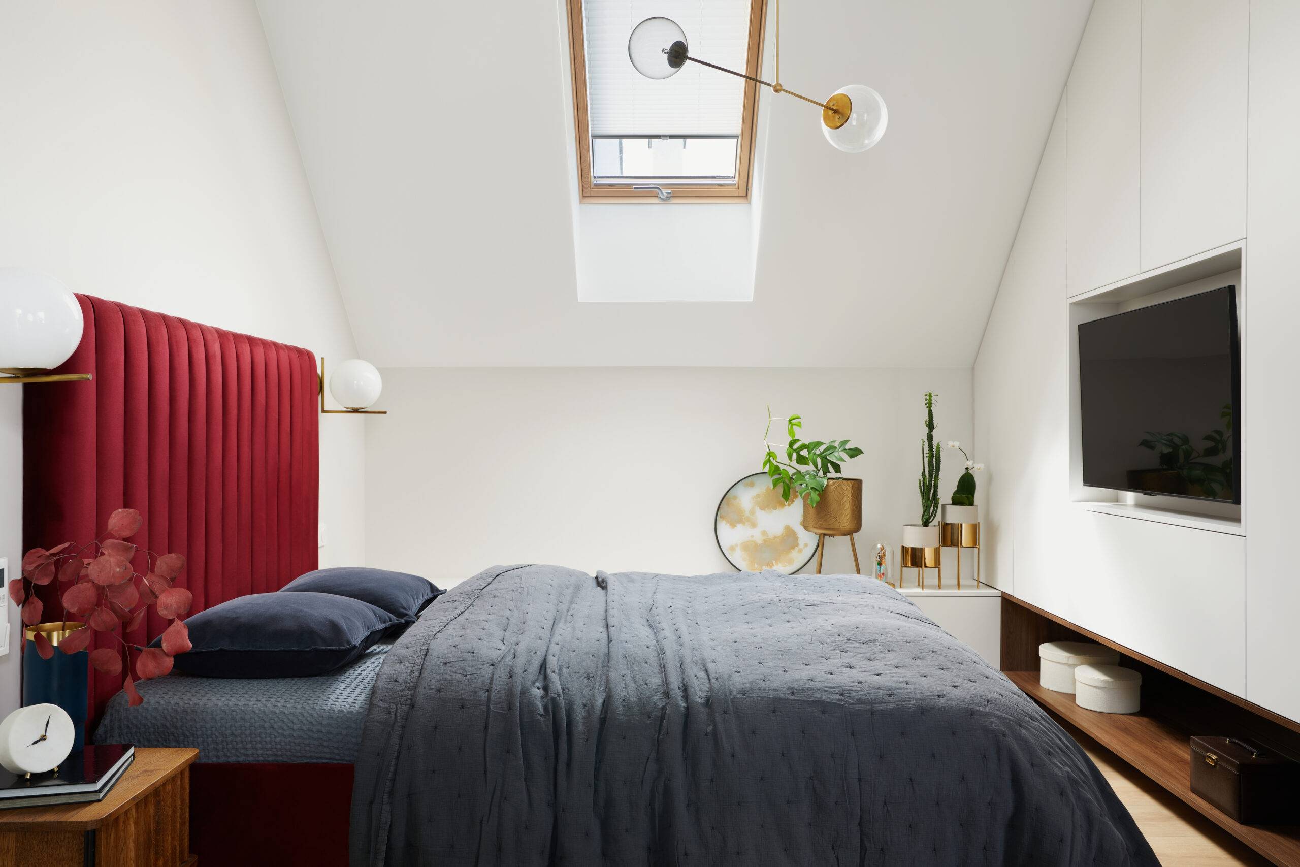 A bedroom with a red headboard.