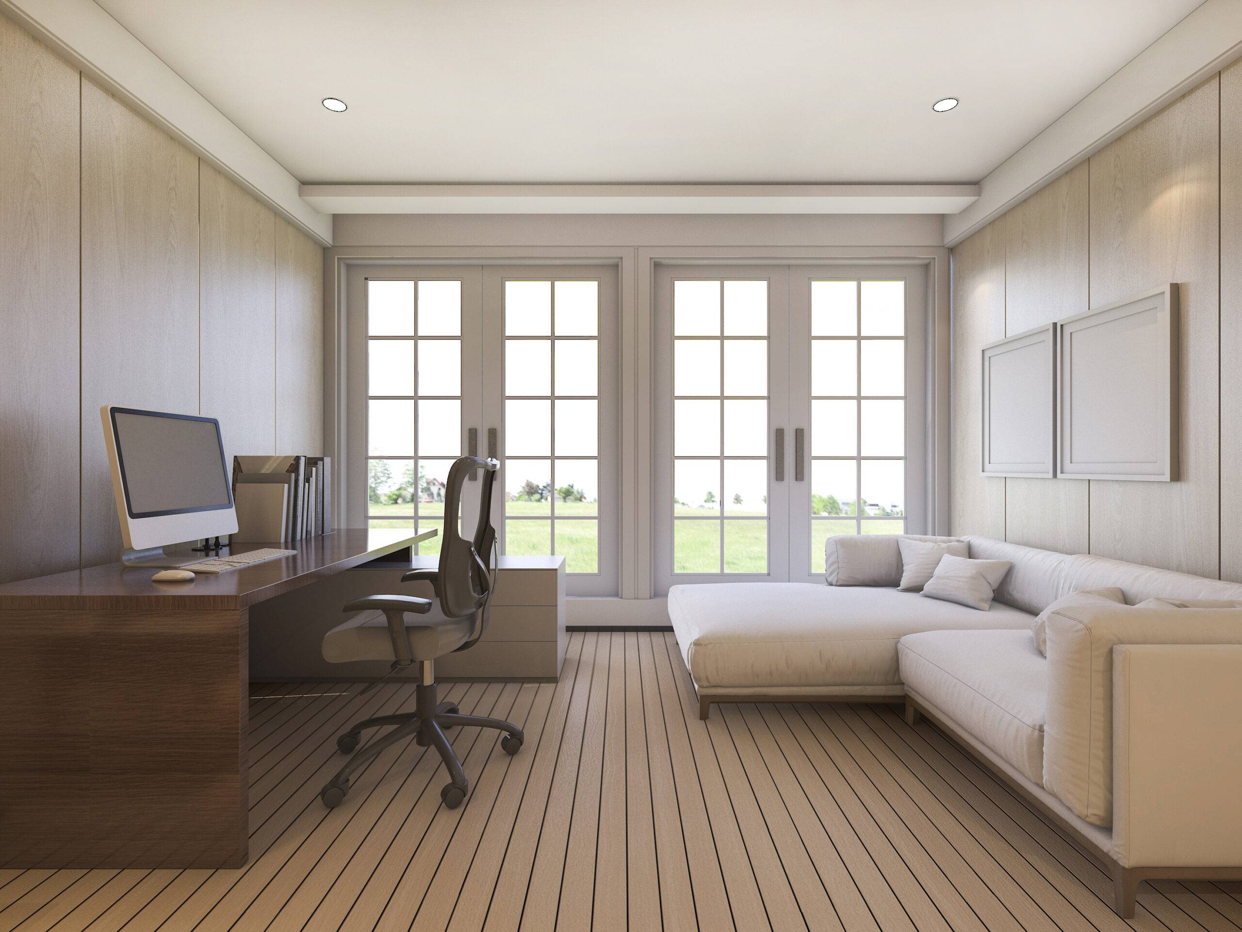 A neutral-colored room with a couch on one wall, a desk on the other, and large bay windows at the end.