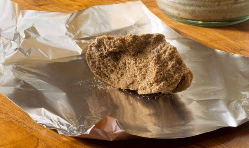 A hardened clump of brown sugar resting on a piece of tin foil.