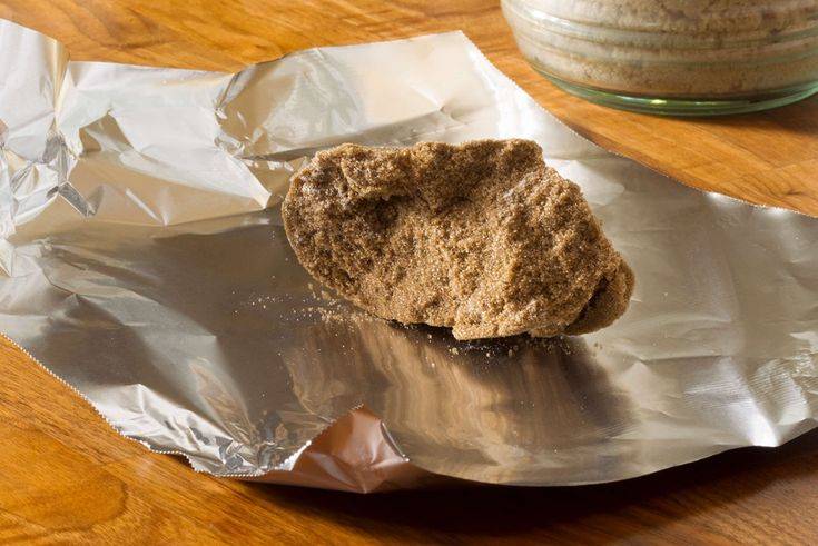 A hardened clump of brown sugar resting on a piece of tin foil.