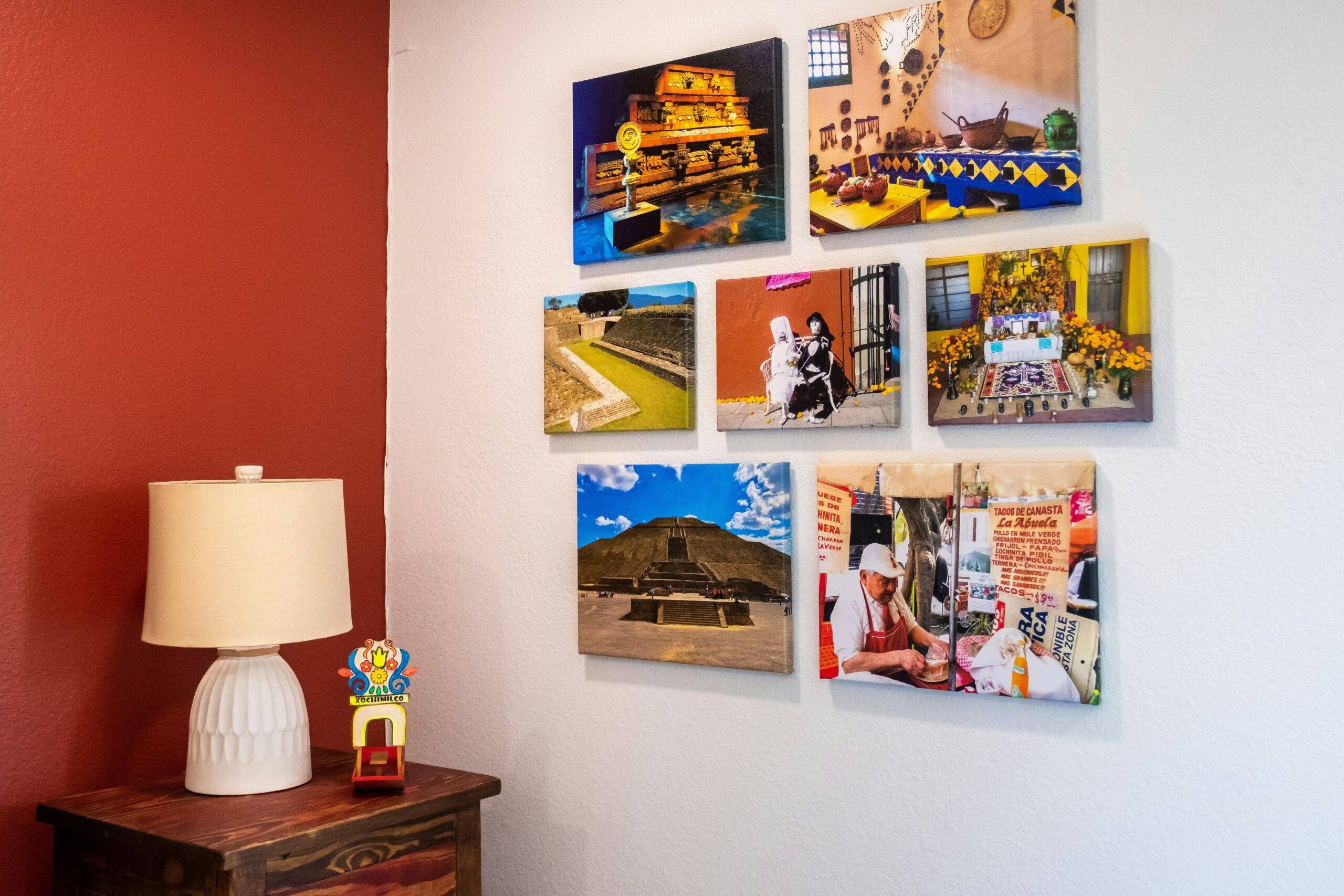 A selection of printed photos hanging together on a wall near an end table.