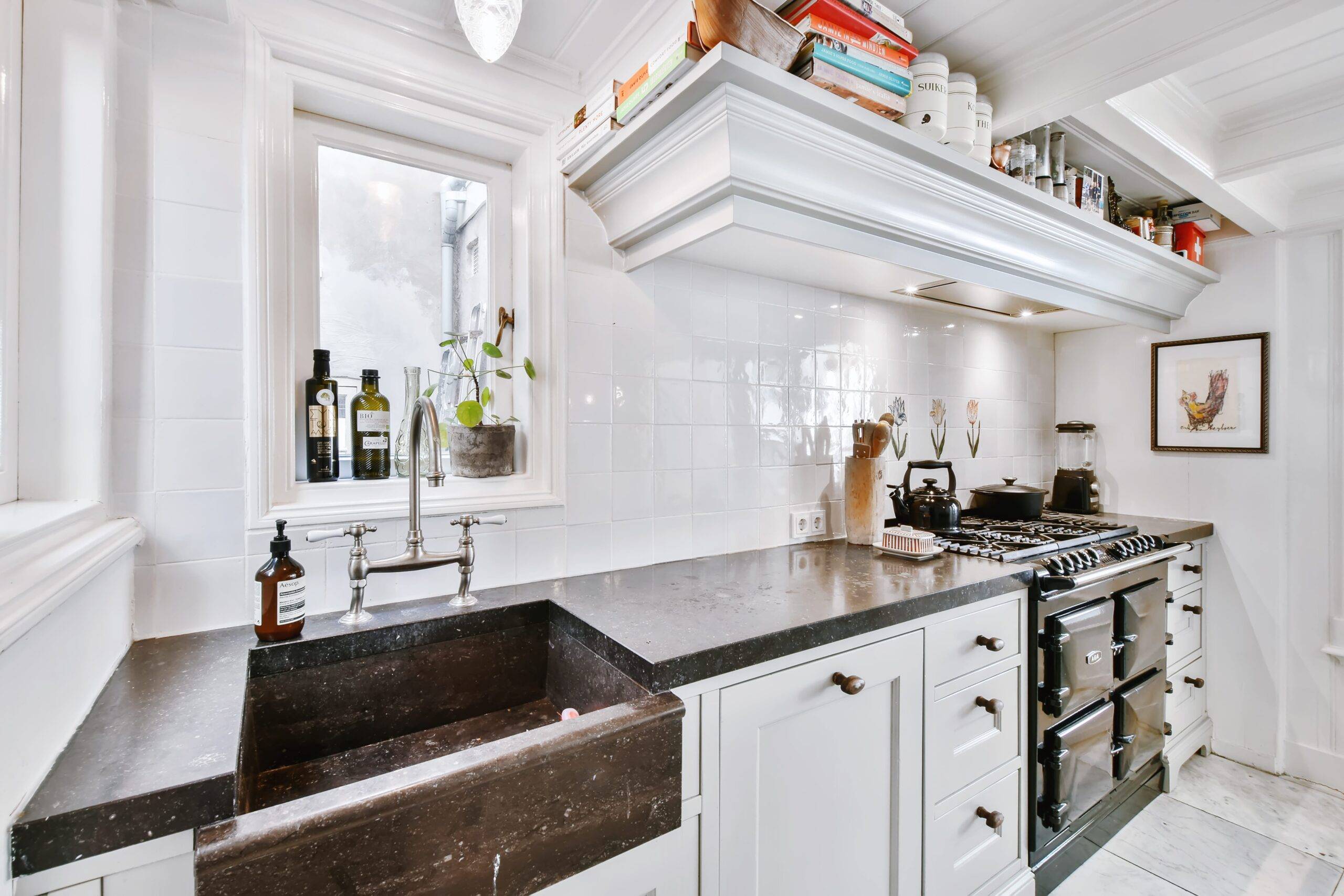 A modern black and white home kitchen with a large country sink.