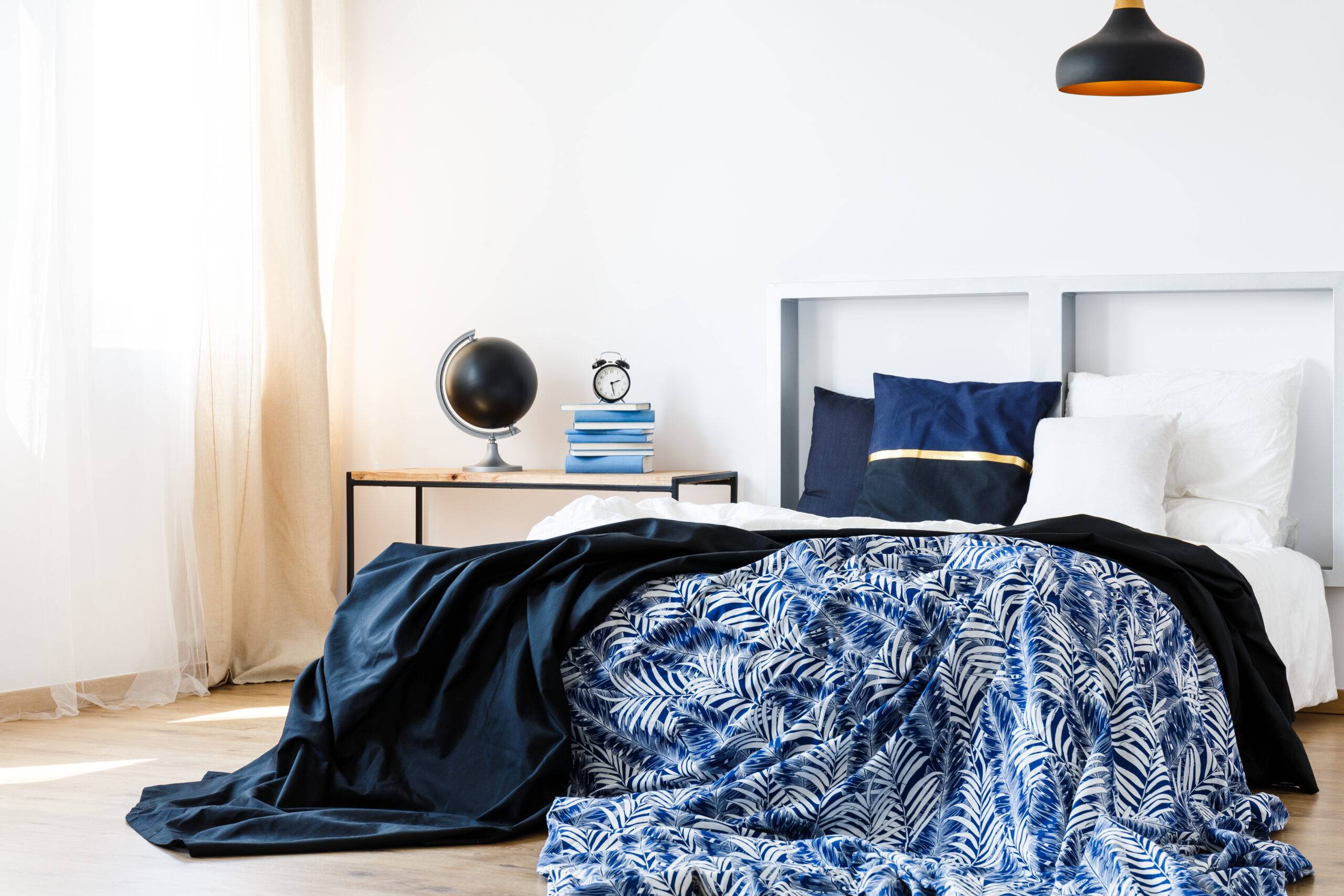 Bed with blue and white bedding and modern headboard