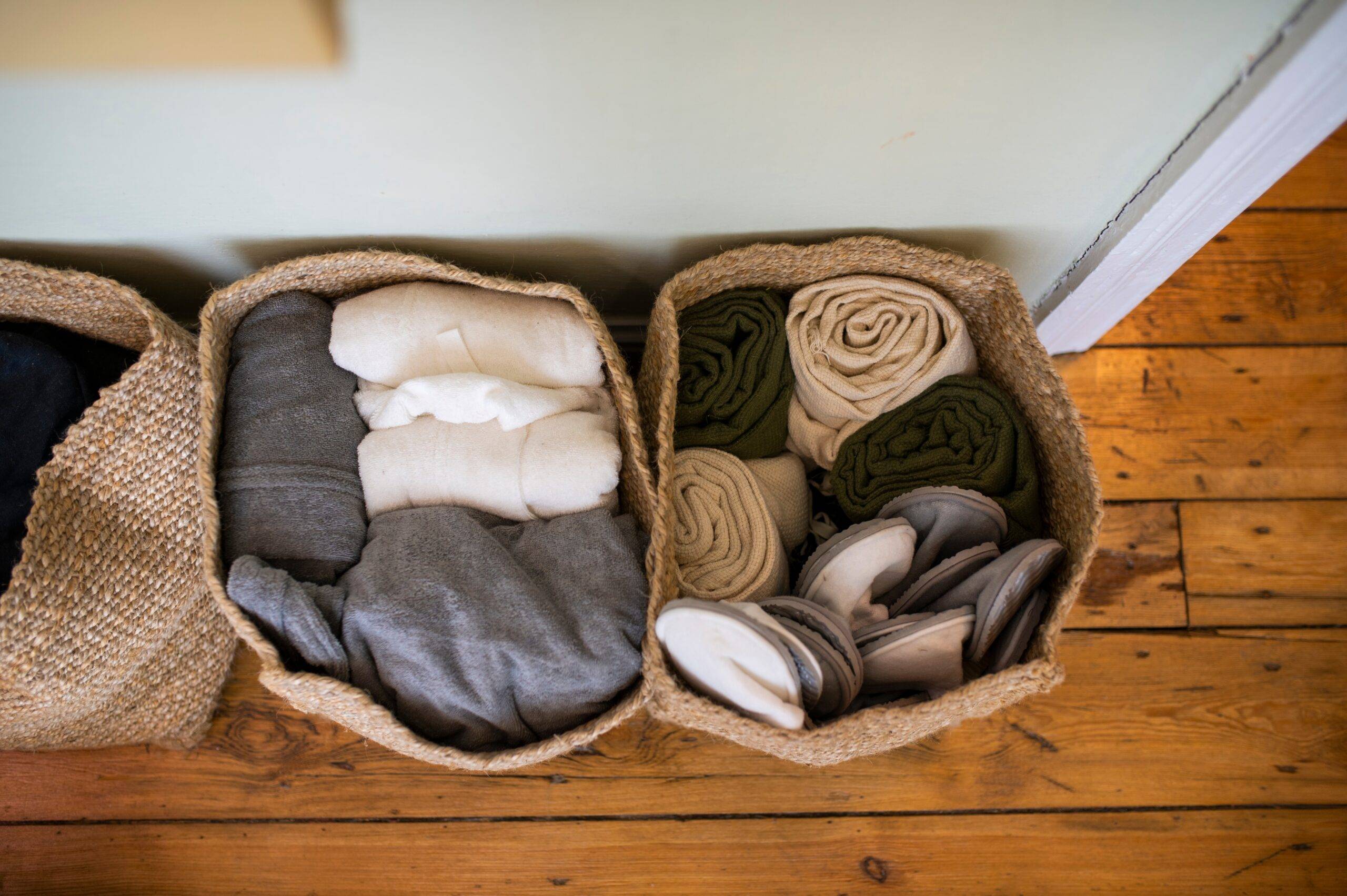 An overhead shot of a new soft baskets filled with folded clothes, the baskets sitting on the floor.