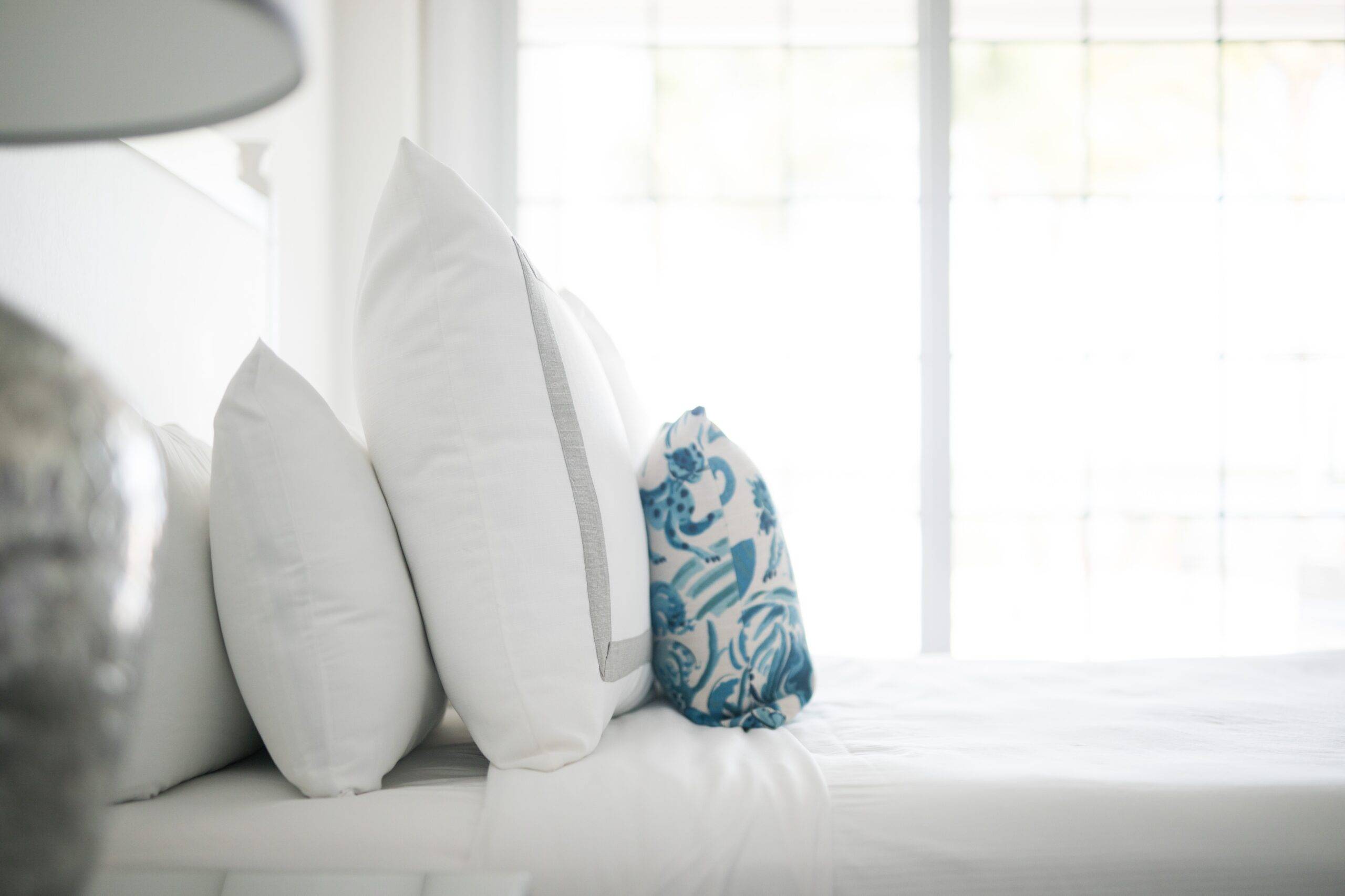 A bed with a few layers of pillows at the headboard.