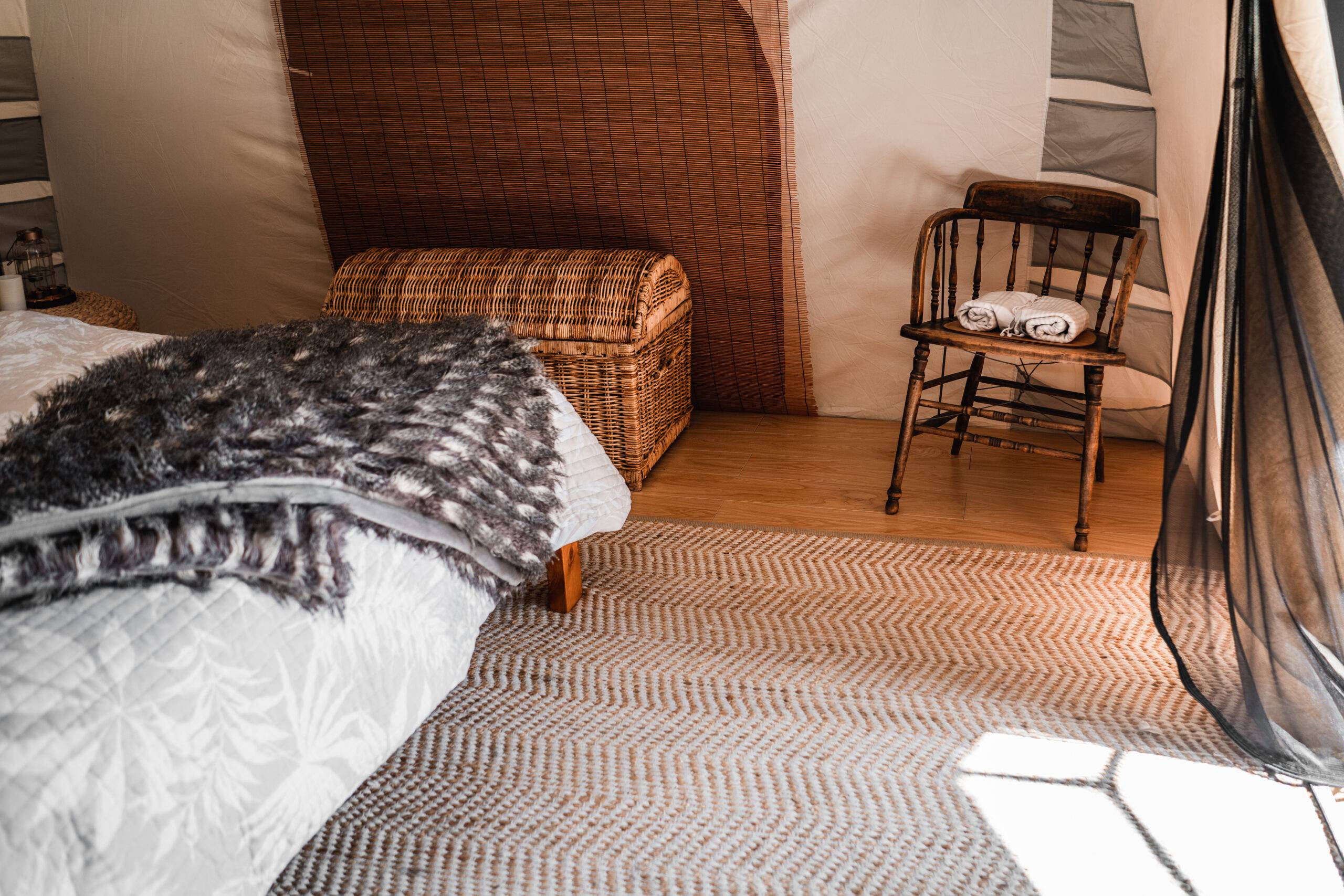 Comfortable bedroom with mat near the large bed in the tent