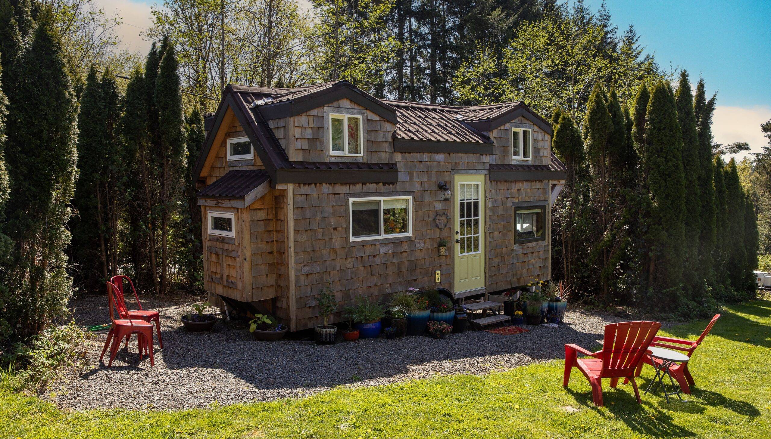 A stone tiny home surrounded by trees.