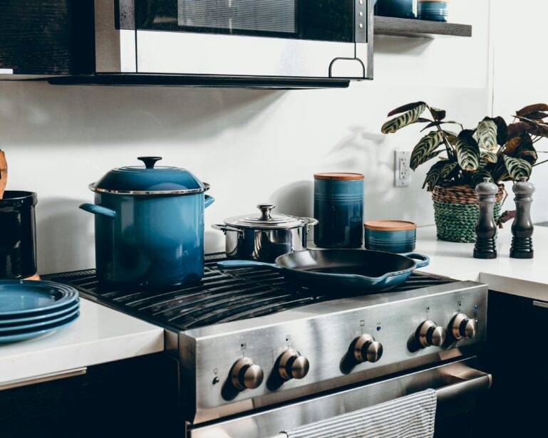 A set of blue cookingware on a stove range.