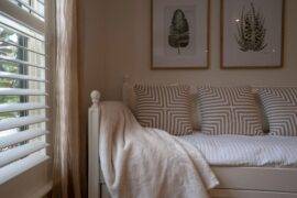 A daybed-style bed next to a window that's letting soft light in.