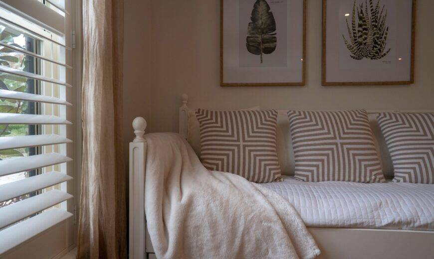 A daybed-style bed next to a window that's letting soft light in.