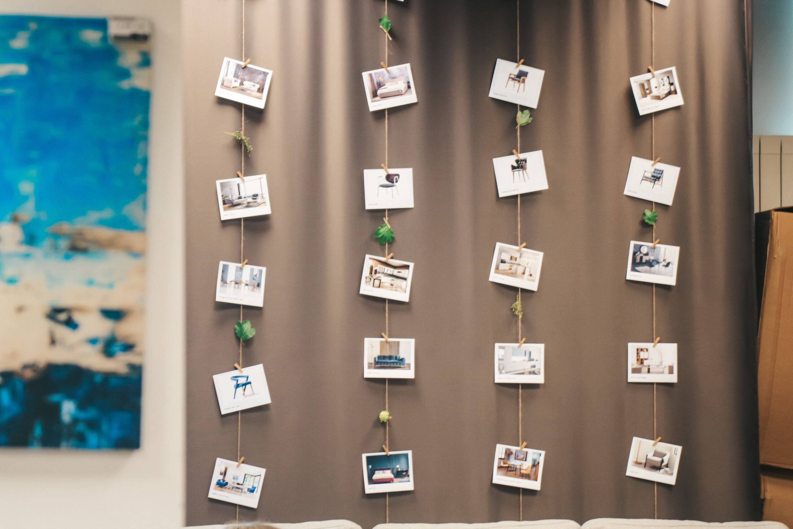 A few rows of polaroids hung up on a wall via twine.