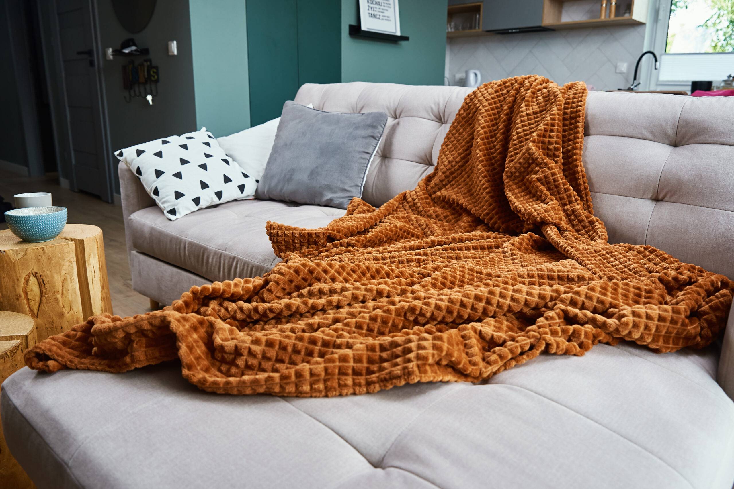 Sofa with plaid and cup of tea. Place for relaxation. Moderm room interior