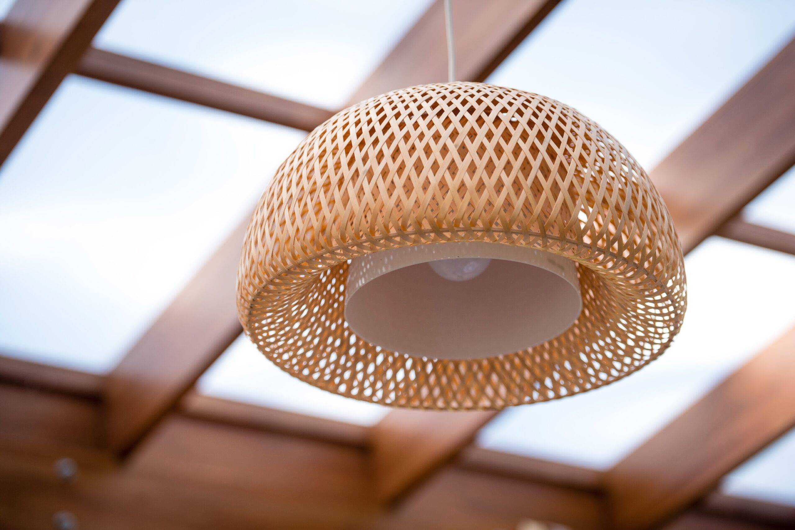 Interior of the outdoor terrace with a wicker wood ceiling lamp.