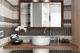 A bathroom vanity with a large, wood-framed mirror hanging above it.