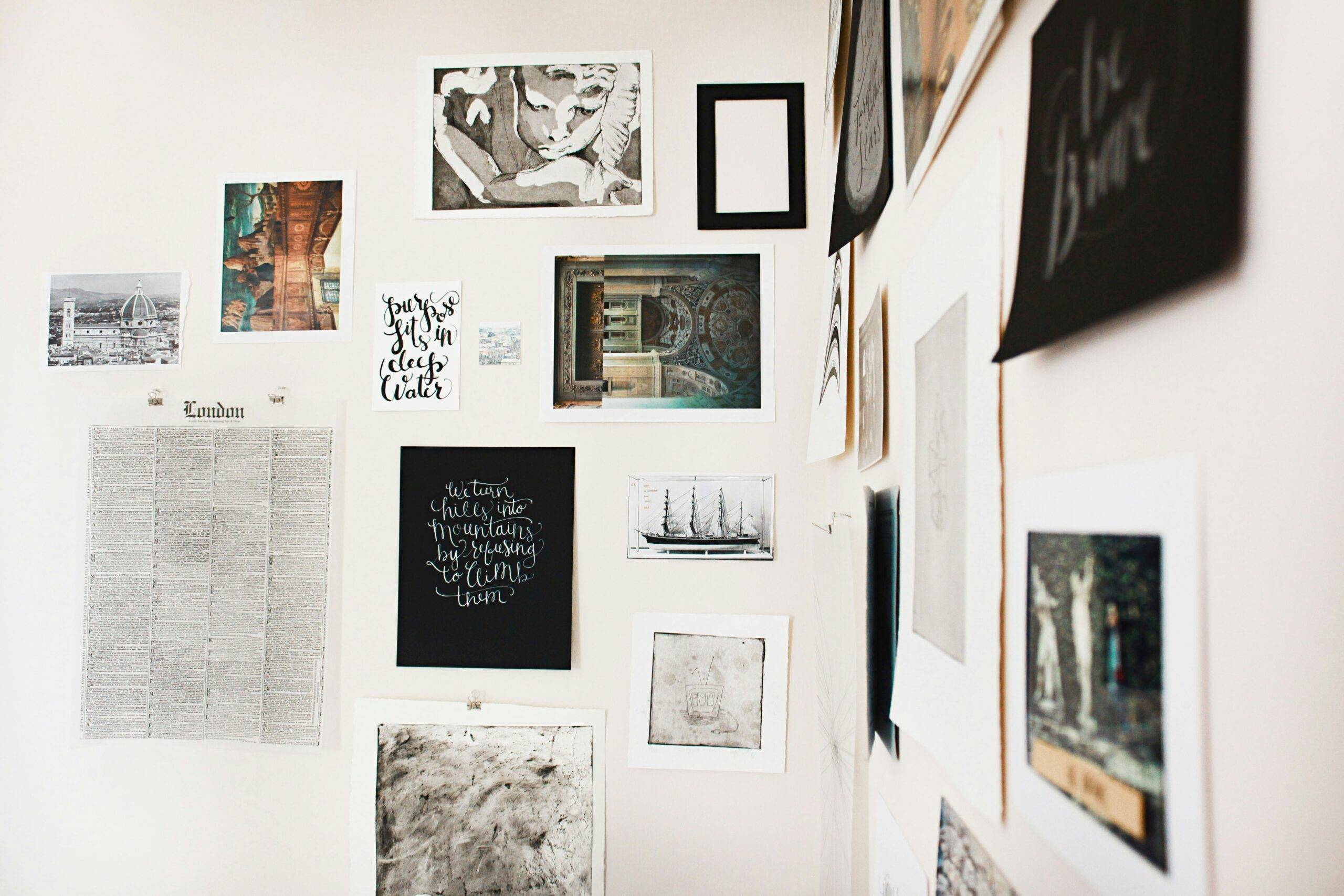 The corner of two walls both covered in unframed art.