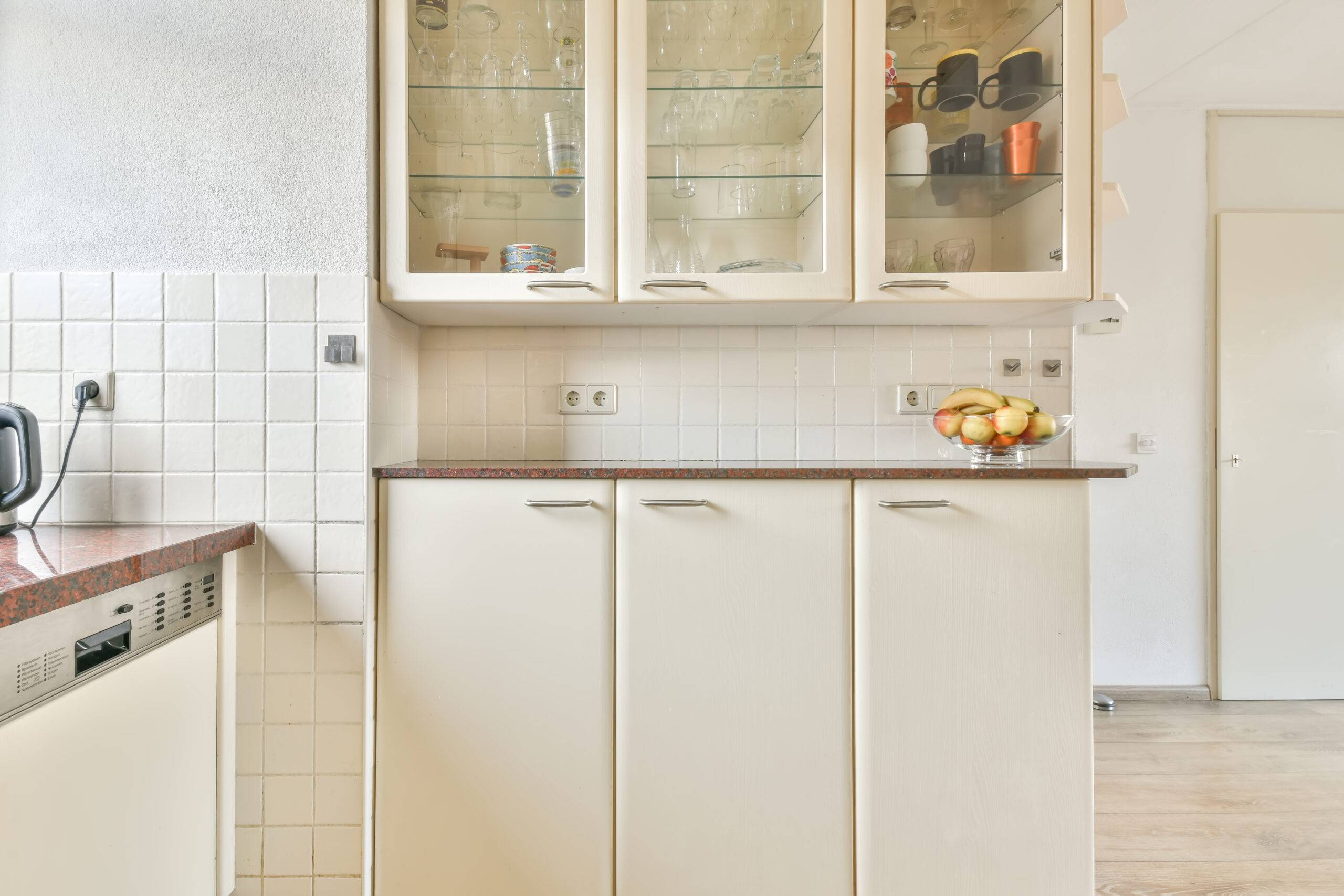 Kitchen in a new luxury home, hardwood floors, light cabinets with glass doors.