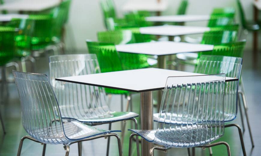 Blurred restaurant with colorful tables and chairs in the lobby of the mall. Beautiful interior. Blurred bokeh basic background for design.