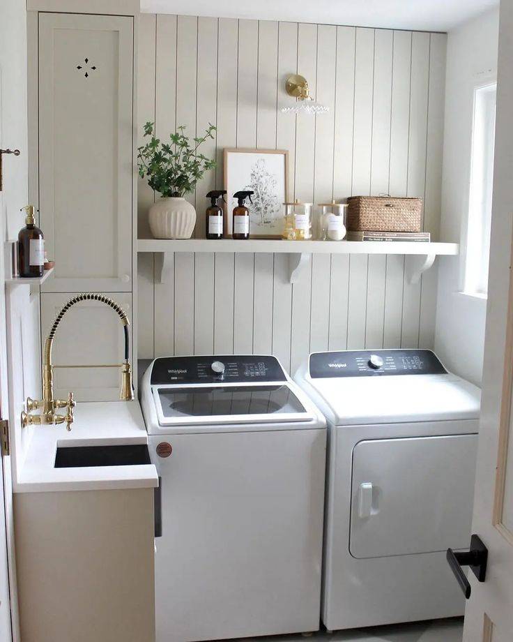 A laundry room with a top-load washing machine.