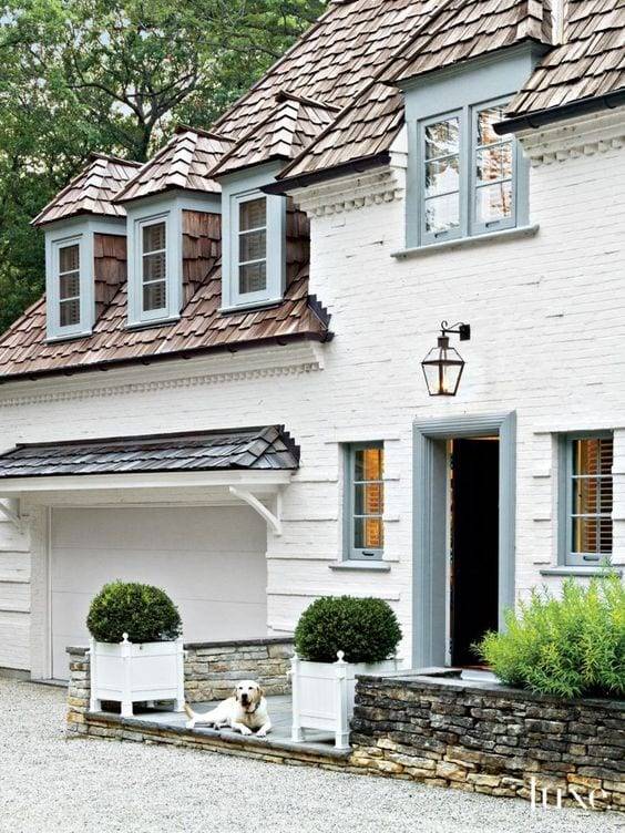 An angled shot of the front of a home with light blue trim around the door and windows.