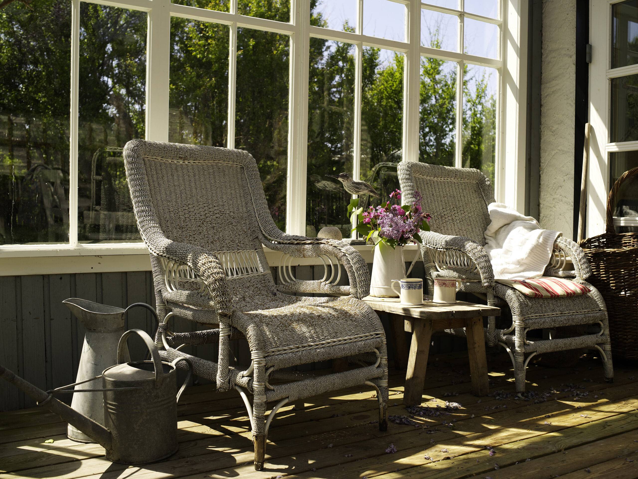 Wicker chairs and side table in sunlit conservatory