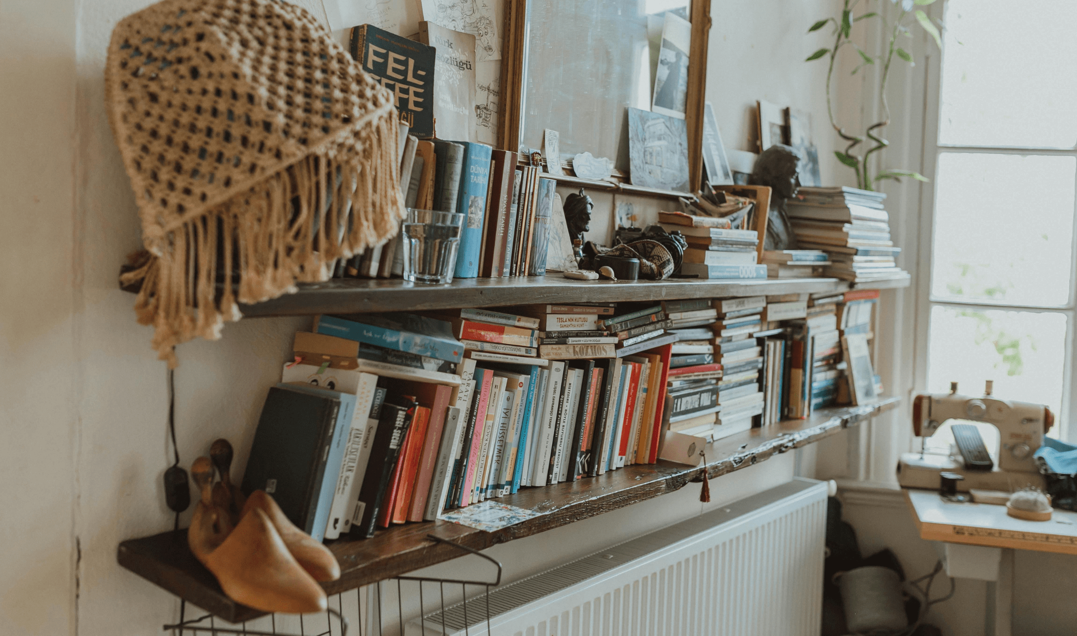 An angled photo of some wall-mounted, open book shelves with books and knick-knacks.