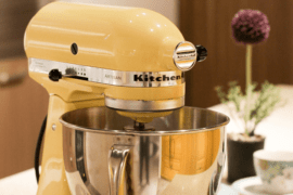 A yellow kitchenaid mixer on a countertop.