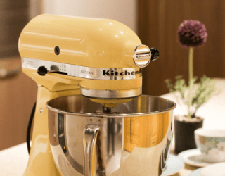 A yellow kitchenaid mixer on a countertop.