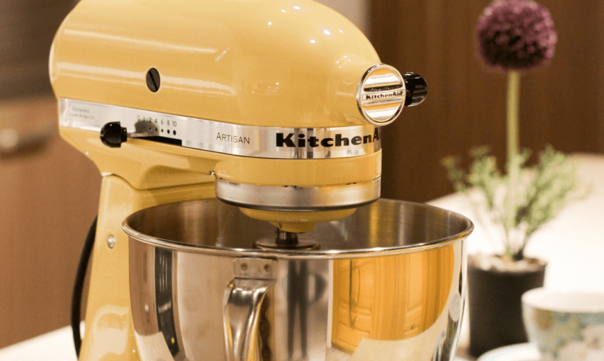 A yellow kitchenaid mixer on a countertop.