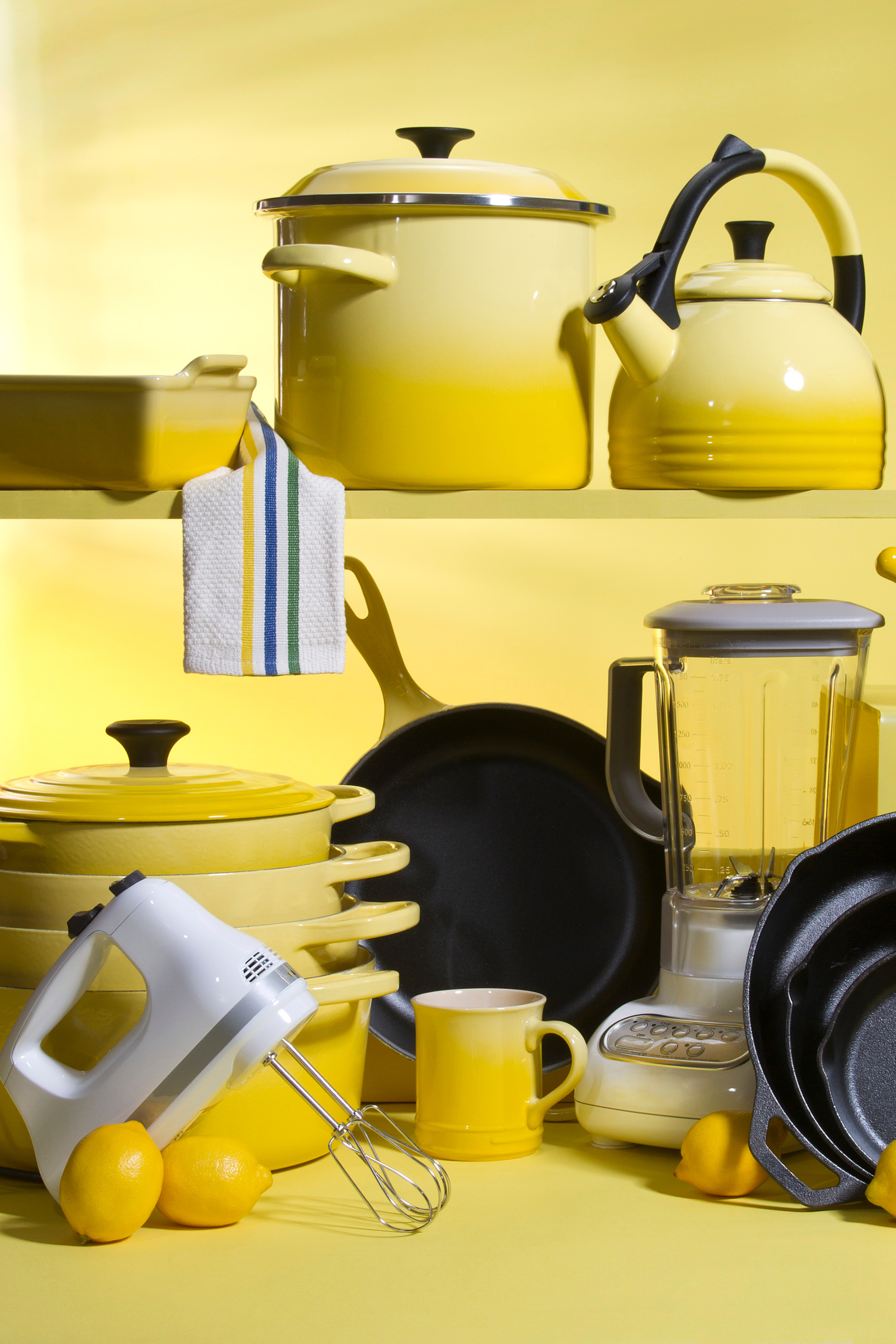 A twotiered shelf filled with matching yellow kitchenware.