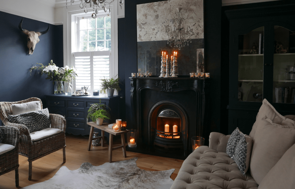 A gothic-style living room with a fireplace focal point and grey seating.