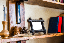 A bookshelf with a small picture frame on it next to a row of books.