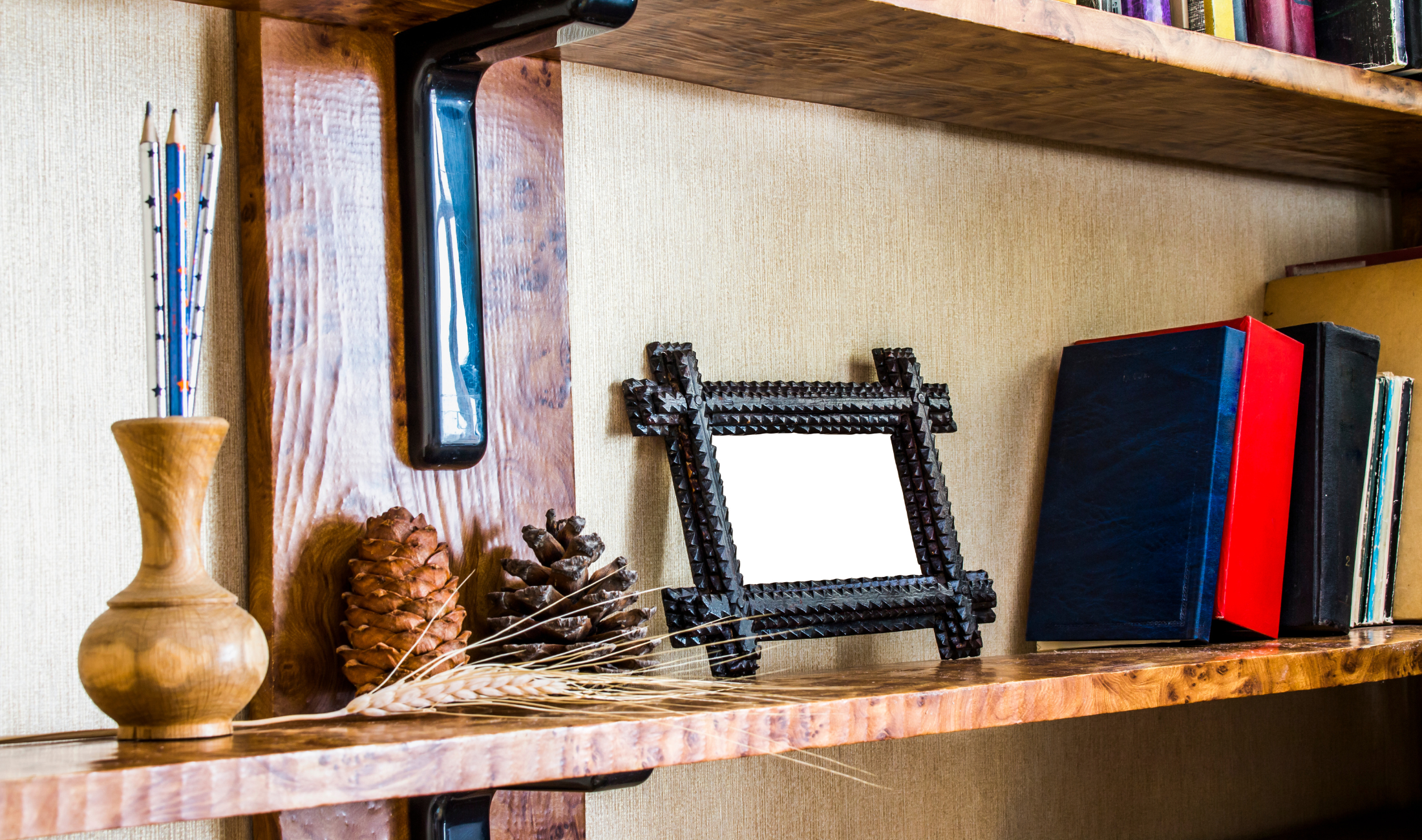 A bookshelf with a small picture frame on it next to a row of books.