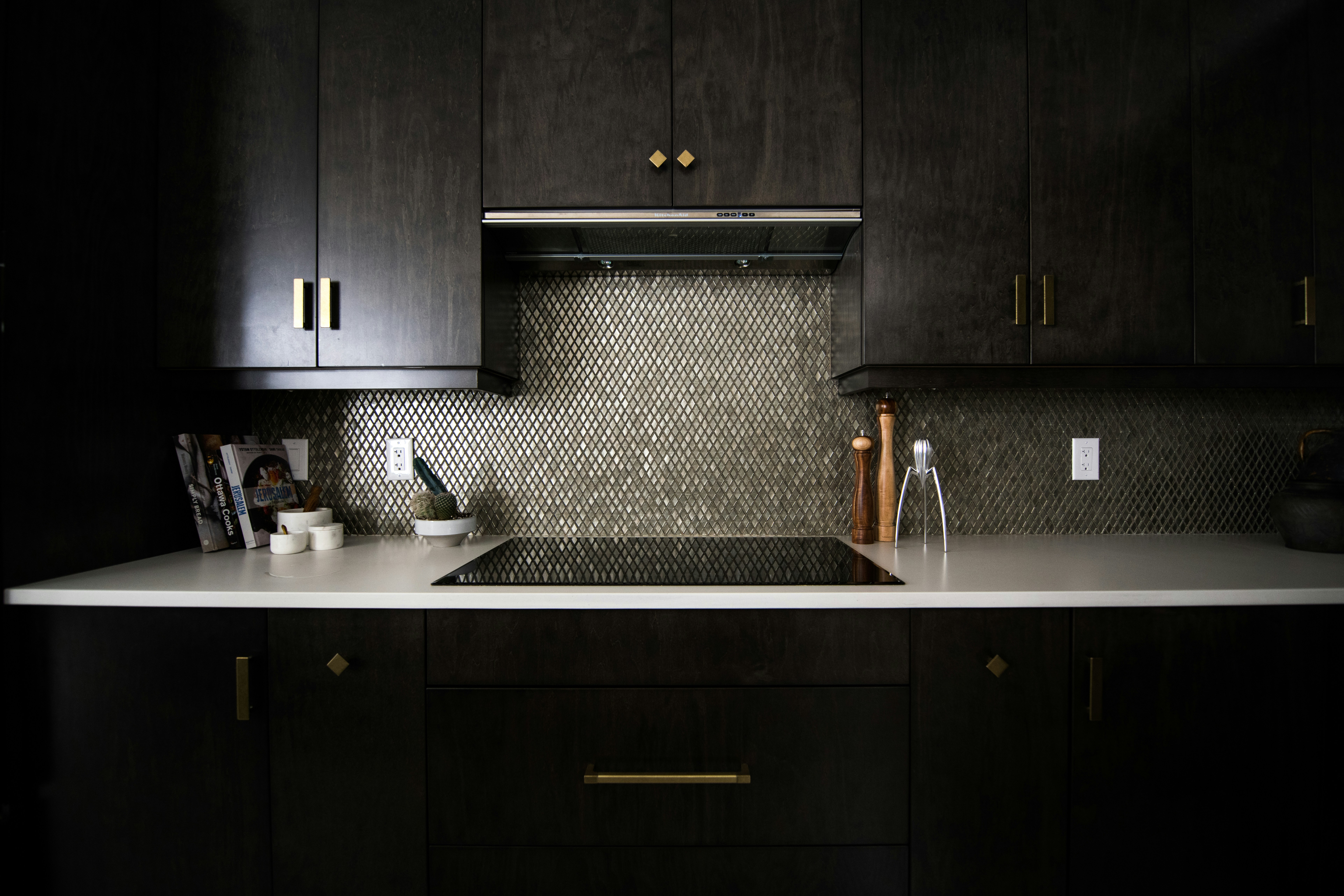 A kitchen with black cabinets and modern hardware.