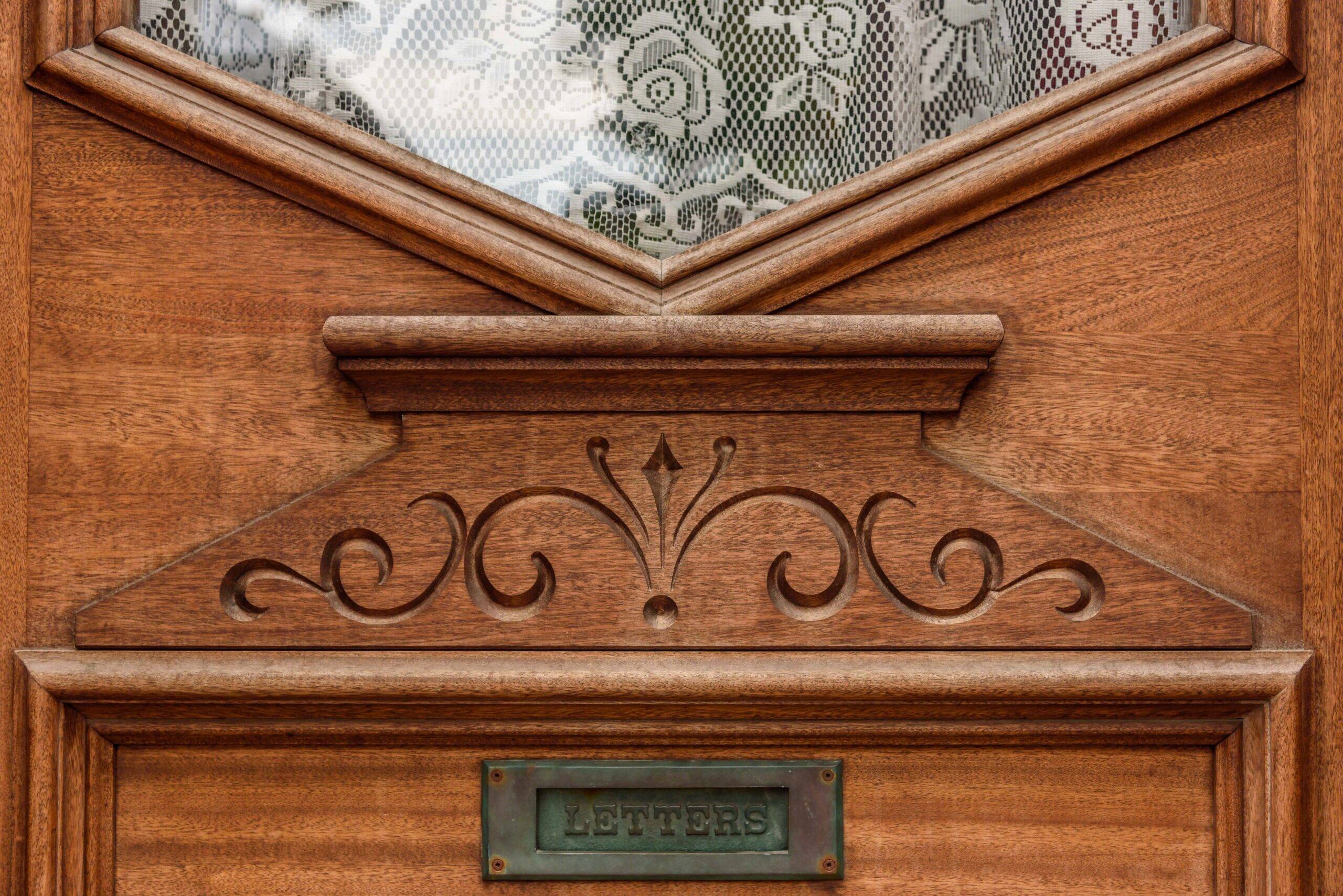 A closeup on a wooden carving detail on a front door