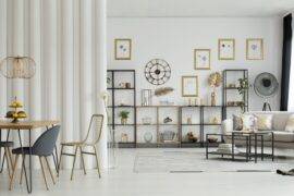 A panoramic shot of a living room with a large curtain between the couch and the dinner table.