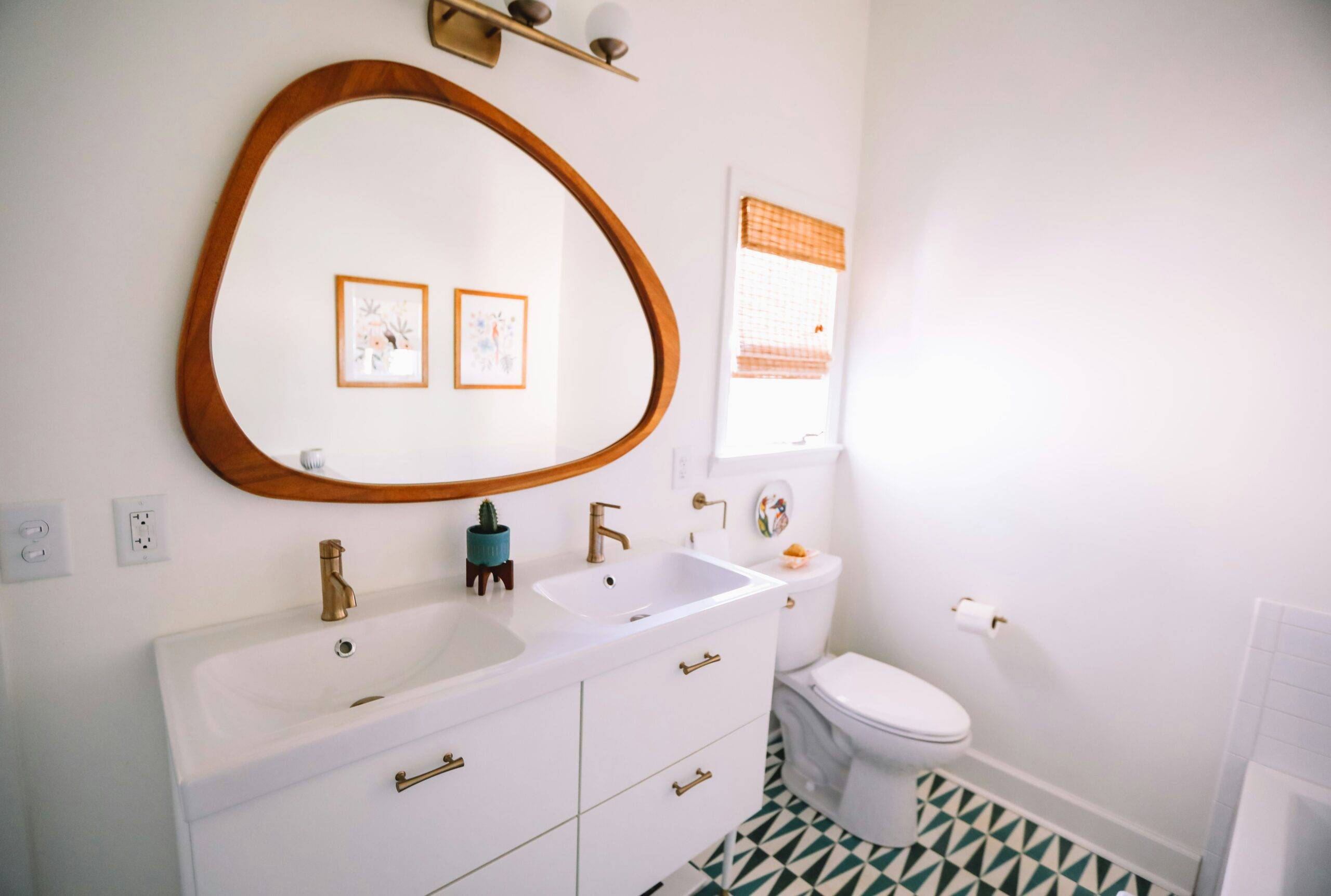 A bathroom with a large, rounded framed mirror.