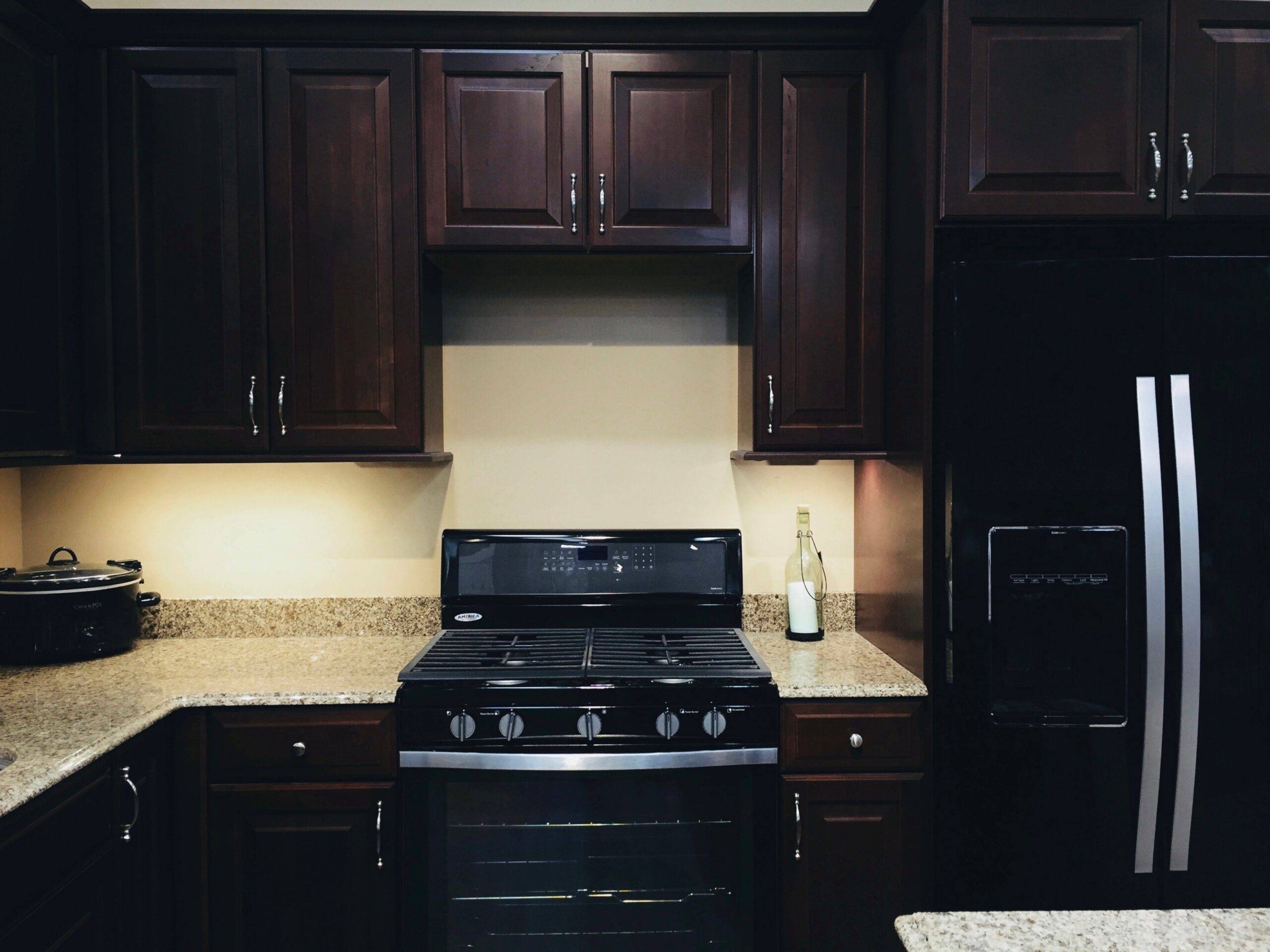 A kitchen with dark cabinets and beige counters.