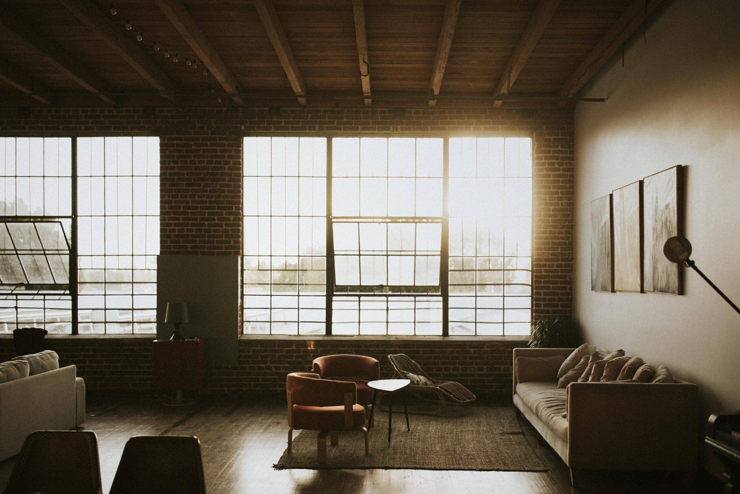 Large industrial windows letting sunlight into a minimalist, modern room.